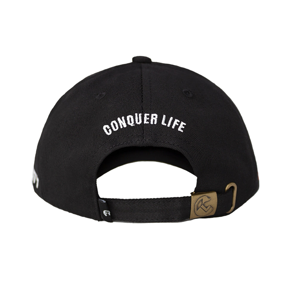 Rear view of cap, strip of black fabric and bronze metal hinge to adjust fit, Conquer Life embroidered in white capitals